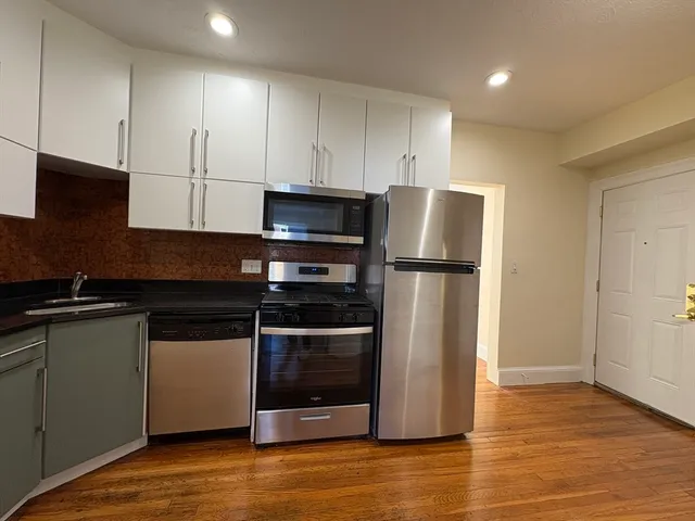 a kitchen with stainless steel appliances granite countertop a refrigerator and a stove top oven