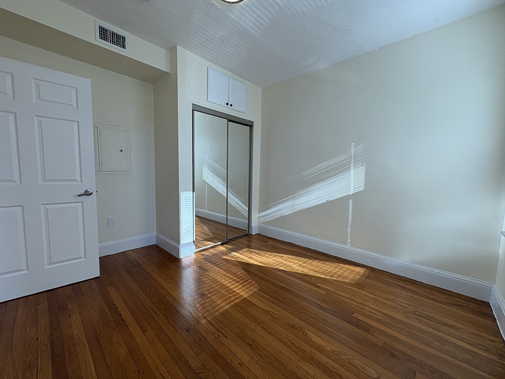 73 Thatcher Street, Unit 202 Brookline, MA 02446 - Photo 5 of 15 a view of an empty room with wooden floor