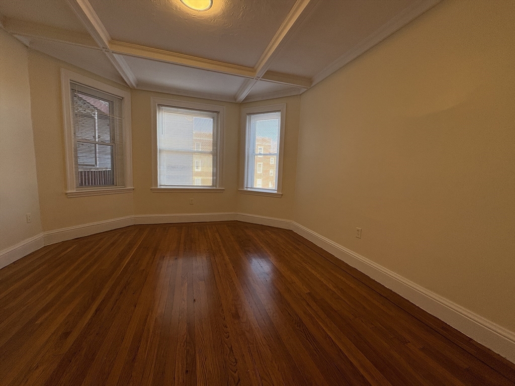 73 Thatcher Street, Unit 202 Brookline, MA 02446 - Photo 9 of 15 a view of an empty room with wooden floor and a window