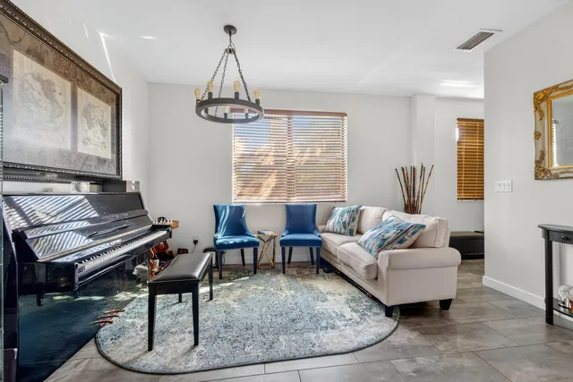 a living room with furniture a dining table and a piano with wooden floor