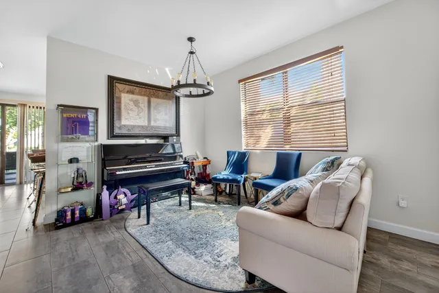 a living room with furniture a piano and a window