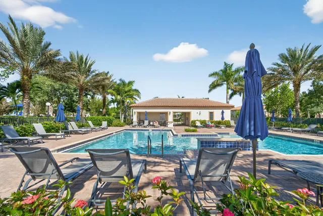 a view of a patio with table and chairs potted plants and palm tree