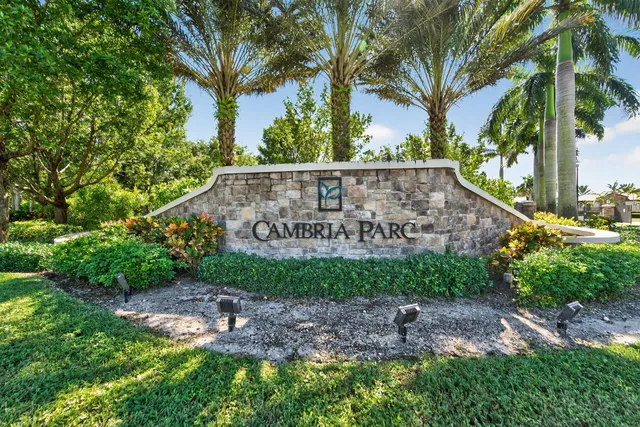a view of a sign in a yard with plants and trees