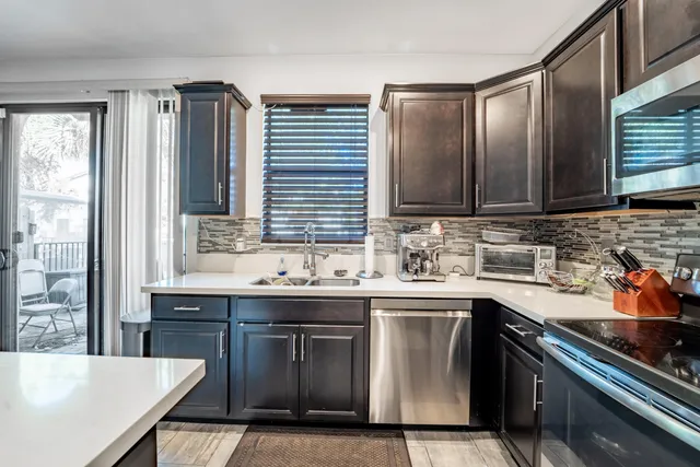 a kitchen with stainless steel appliances granite countertop a sink stove and cabinets