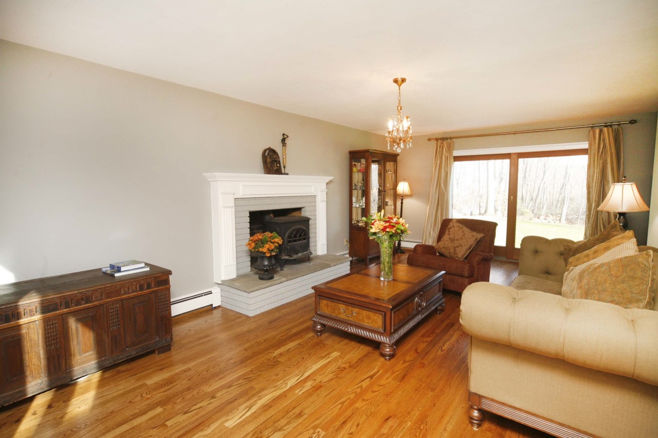 51 Journeys End Road New Canaan, CT 06840 - Photo 7 of 17 a living room with furniture a fireplace and a chandelier