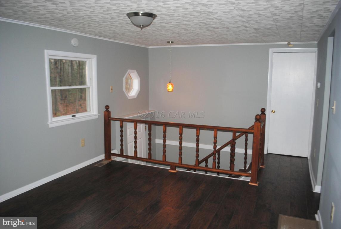 31140 McCormick Swamp Road Princess Anne, MD 21853 - Photo 3 of 20 an empty room with wooden floor and windows