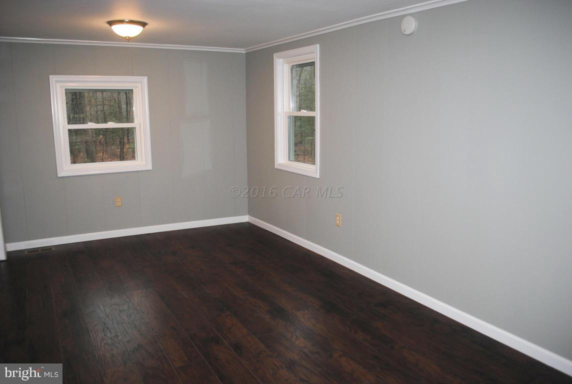 31140 McCormick Swamp Road Princess Anne, MD 21853 - Photo 5 of 20 an empty room with wooden floor and windows