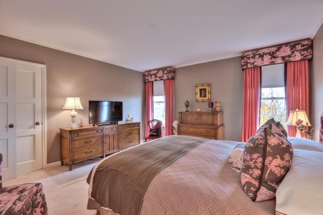 a bedroom with a bed chair and dresser