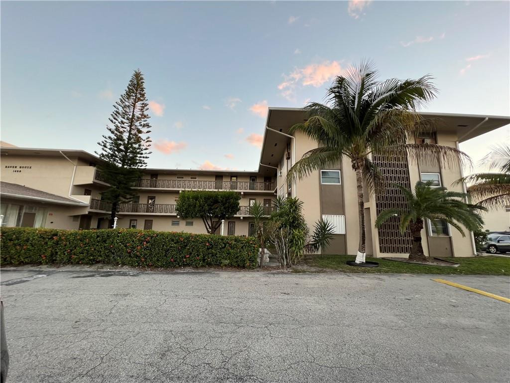 1250 East Sample Road, Unit 208 Pompano Beach, FL 33064 - Photo 17 of 19 a front view of house with a yard and potted plants