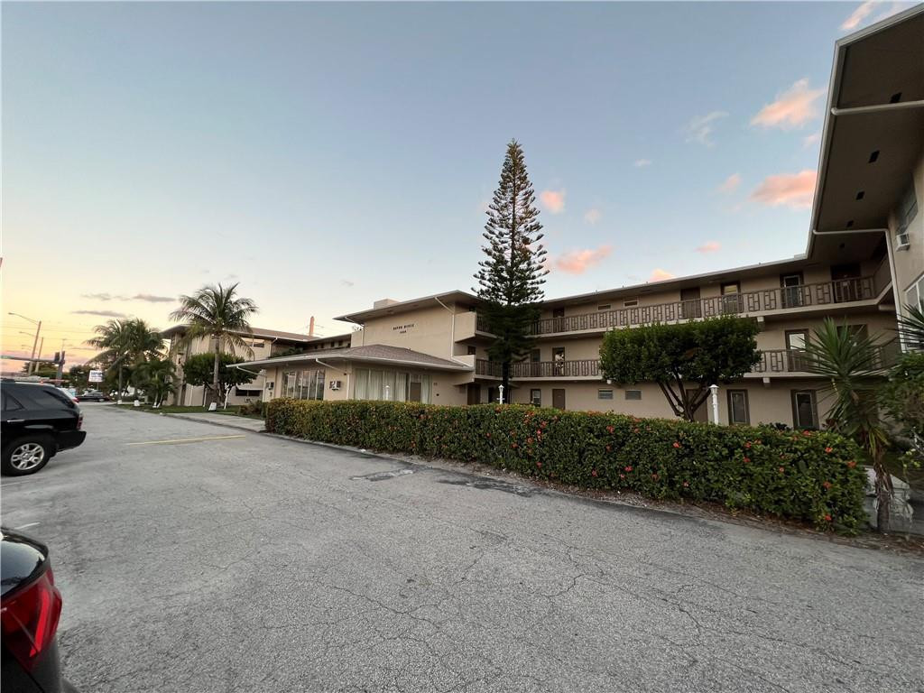 1250 East Sample Road, Unit 208 Pompano Beach, FL 33064 - Photo 18 of 19 a front view of a house with a yard and garage