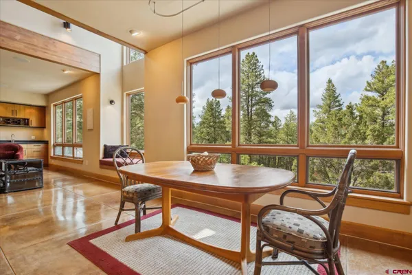 a dining room with furniture a rug and a large window