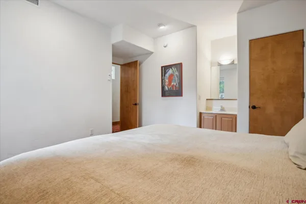 a bedroom with a bed and a mirror