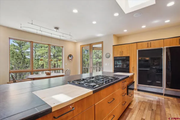 a large kitchen with stainless steel appliances a large counter top a stove and a refrigerator