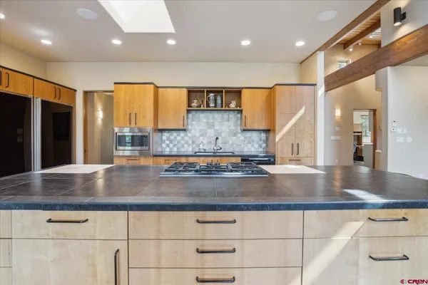 a view of a kitchen with stainless steel appliances granite countertop a sink and a counter top space