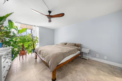 a bed sitting in a room next to a potted plant
