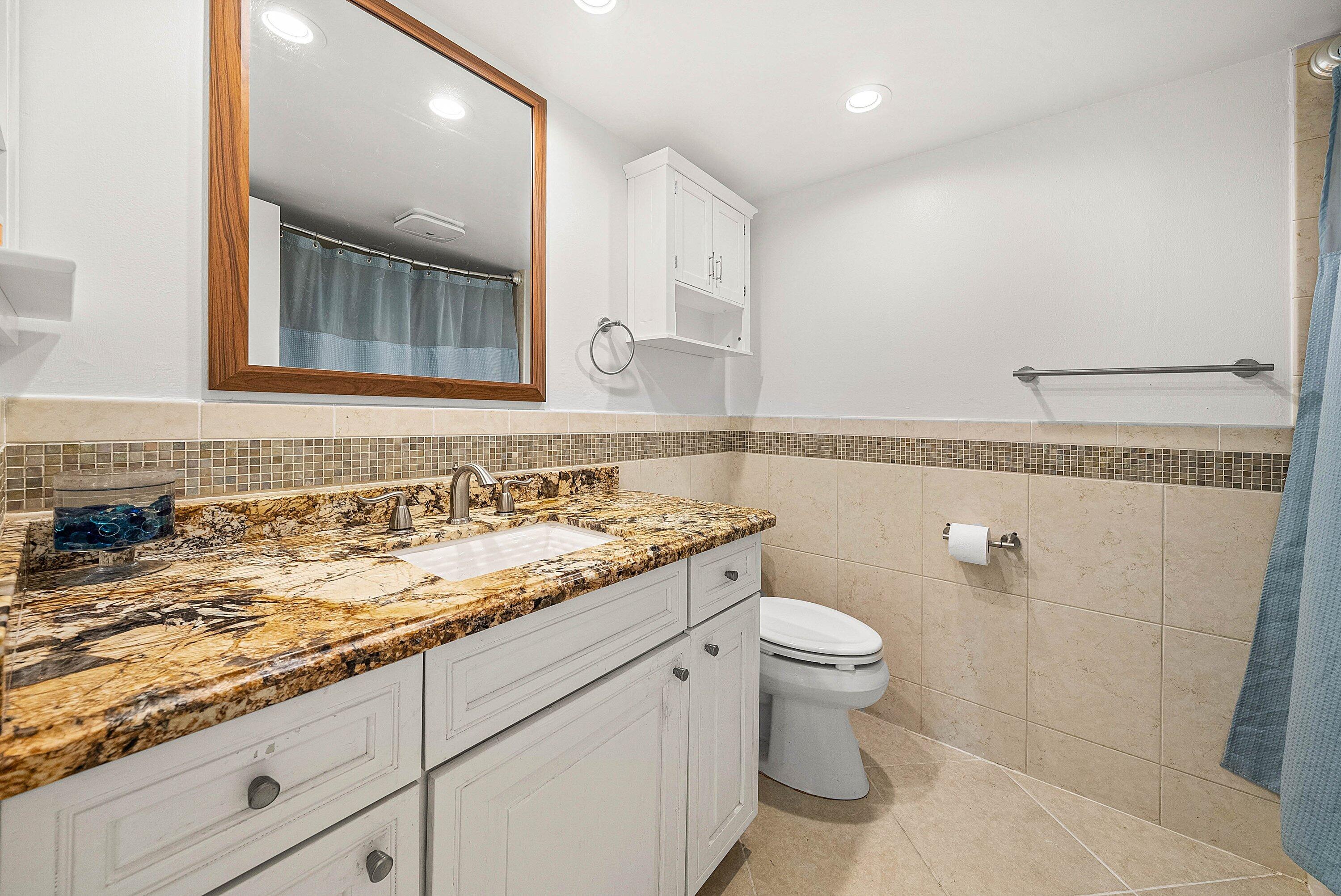 6699 Northwest 2nd Avenue, Unit 415 Boca Raton, FL 33487 - Photo 17 of 27 a bathroom with a granite countertop sink and a mirror