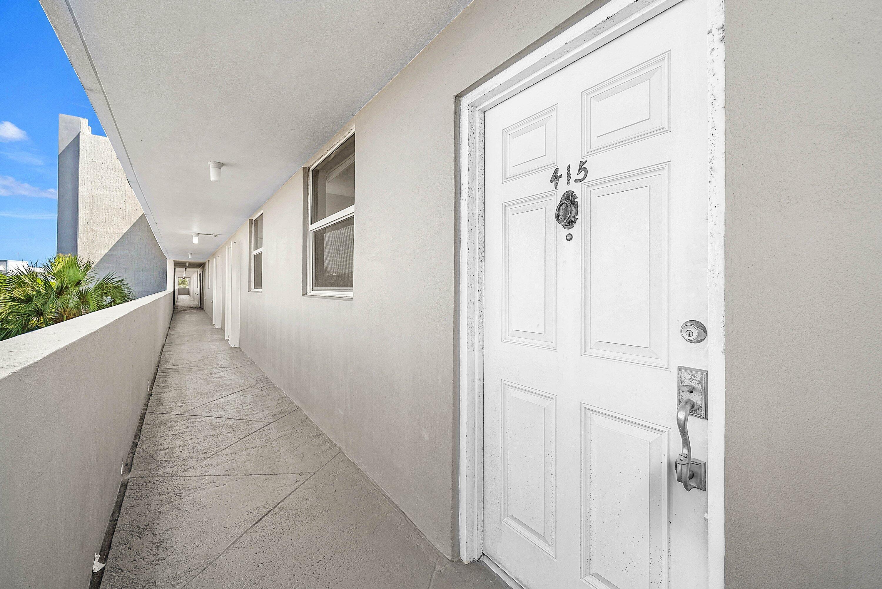 6699 Northwest 2nd Avenue, Unit 415 Boca Raton, FL 33487 - Photo 5 of 27 a view of a hallway with wooden shelves