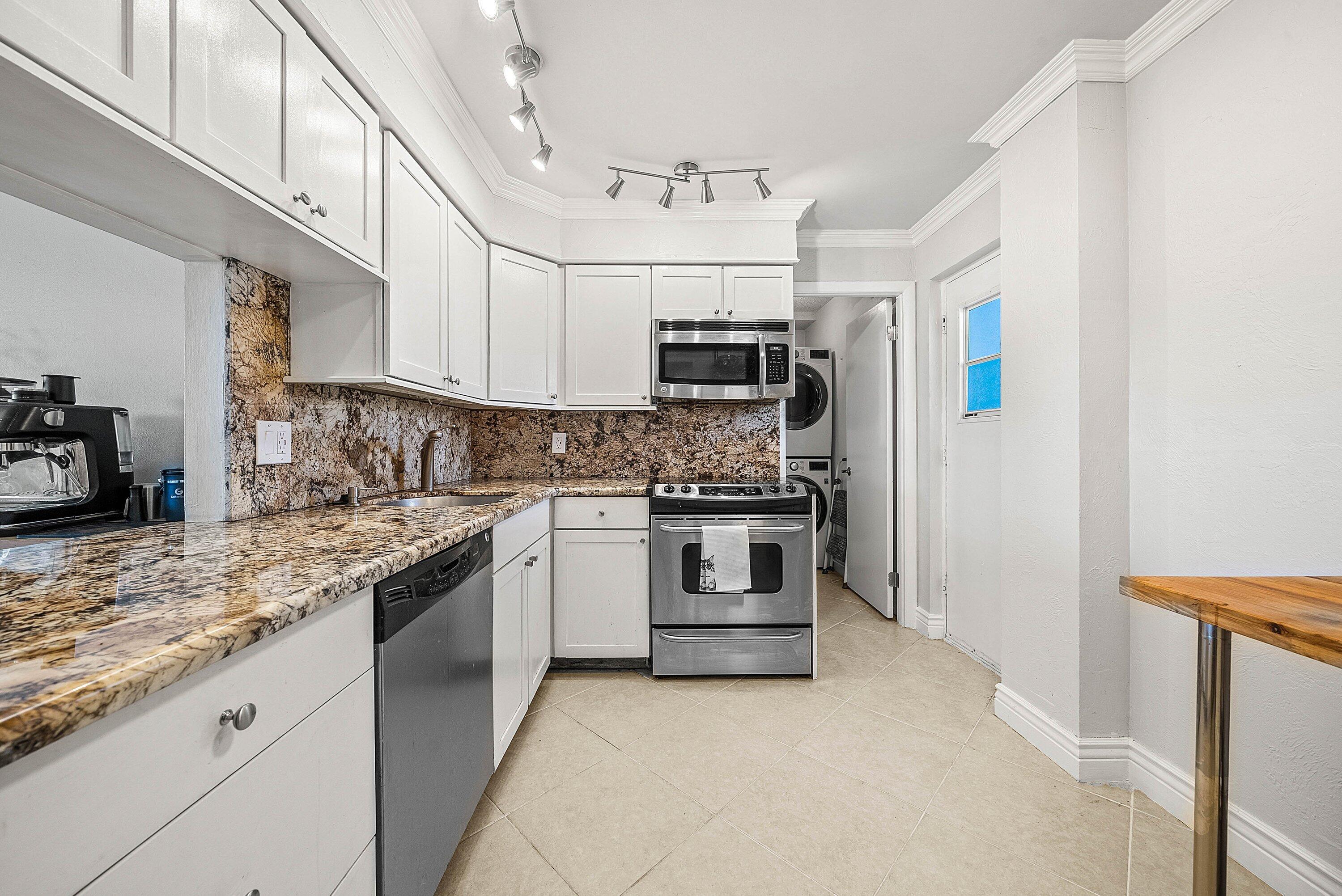 6699 Northwest 2nd Avenue, Unit 415 Boca Raton, FL 33487 - Photo 6 of 27 a kitchen with kitchen island granite countertop a stove sink and microwave