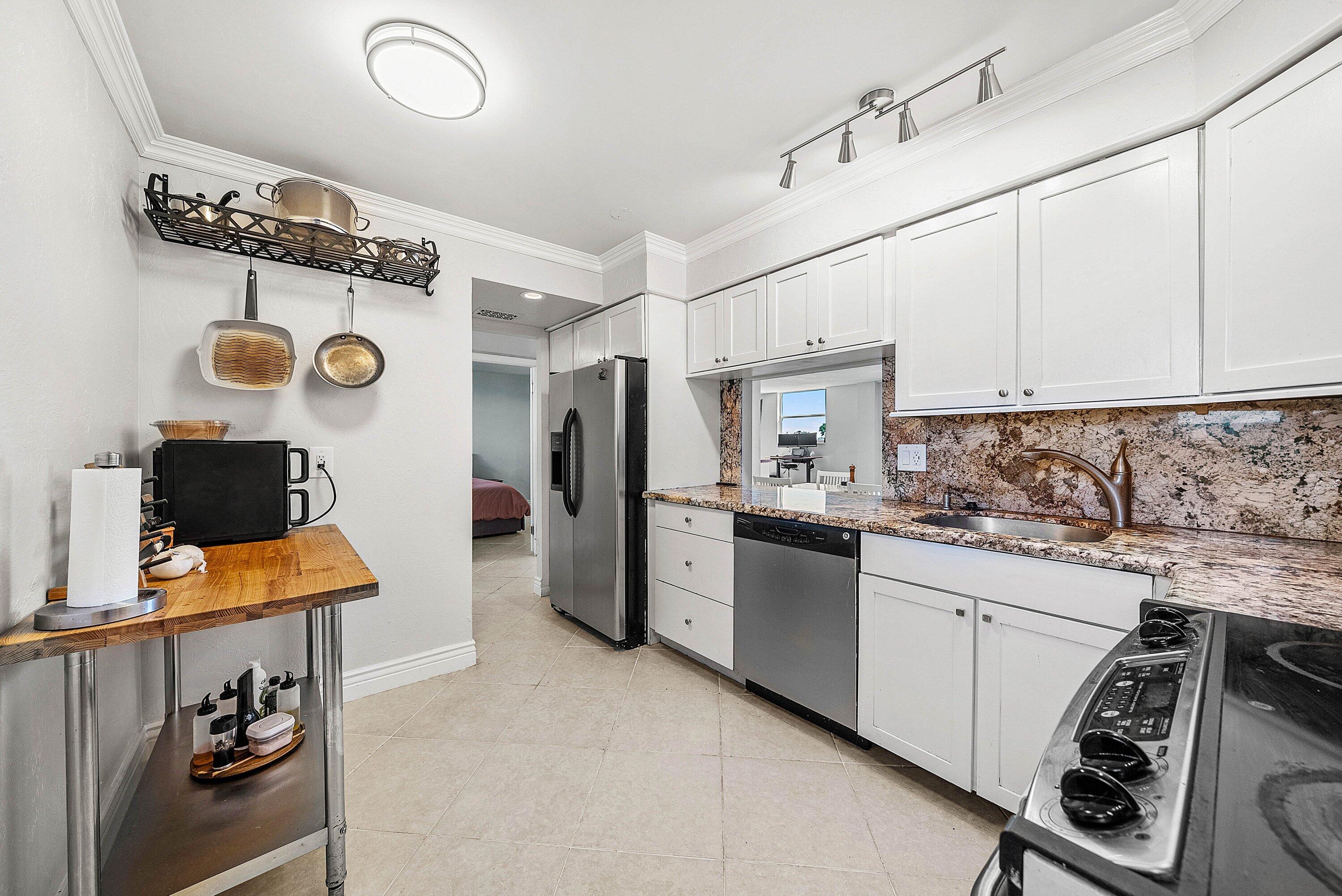 6699 Northwest 2nd Avenue, Unit 415 Boca Raton, FL 33487 - Photo 7 of 27 a kitchen with stainless steel appliances granite countertop a sink and cabinets