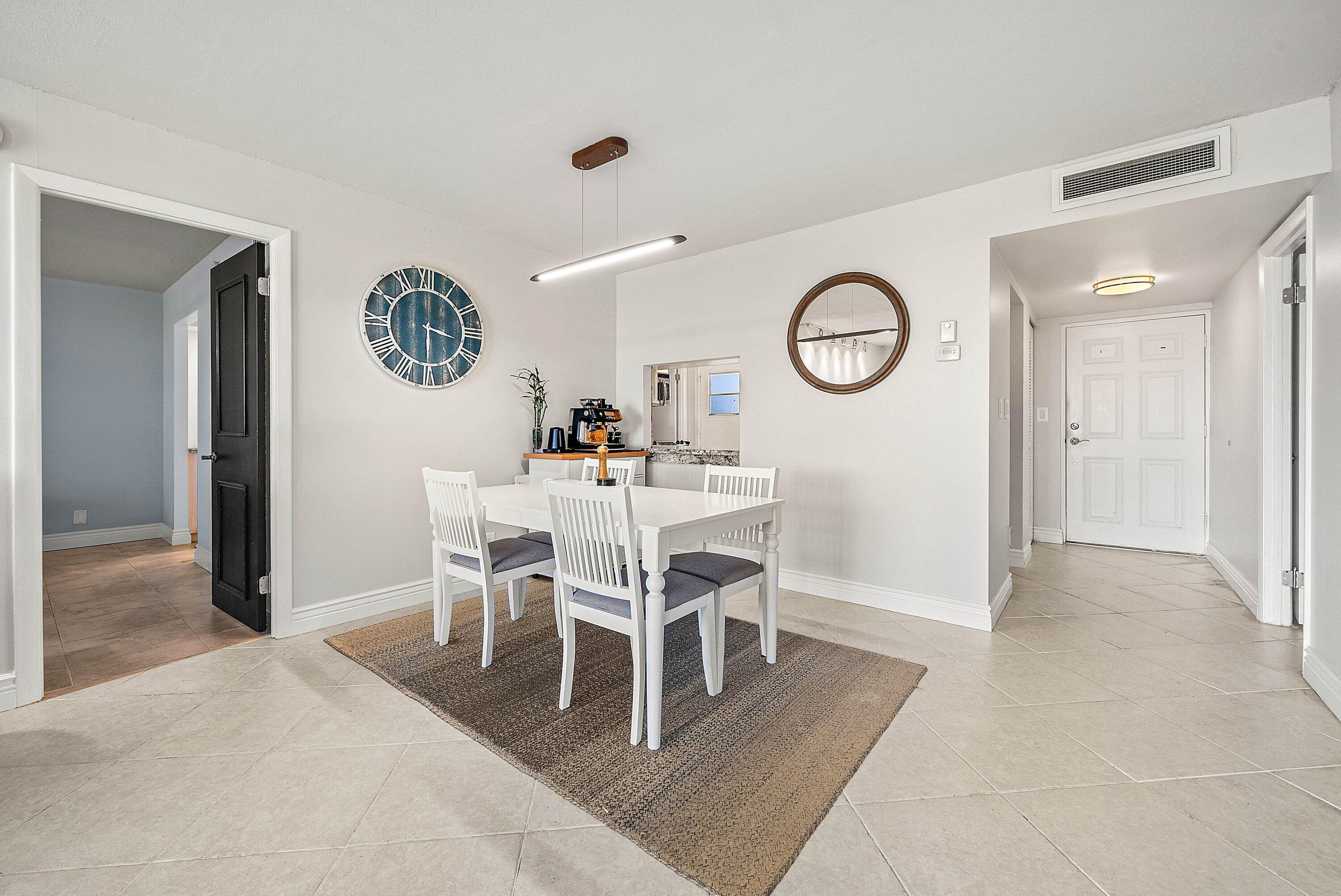 6699 Northwest 2nd Avenue, Unit 415 Boca Raton, FL 33487 - Photo 10 of 27 a dining room with furniture and a clock
