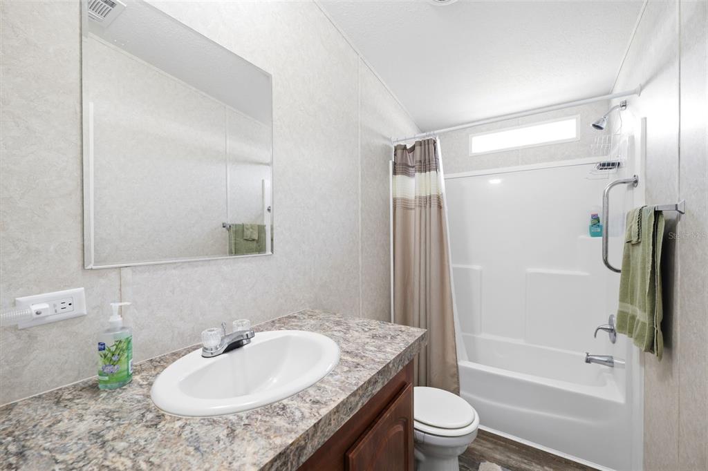 3183 Cedley Road Dade City, FL 33523 - Photo 17 of 48 a bathroom with a granite countertop sink toilet and shower
