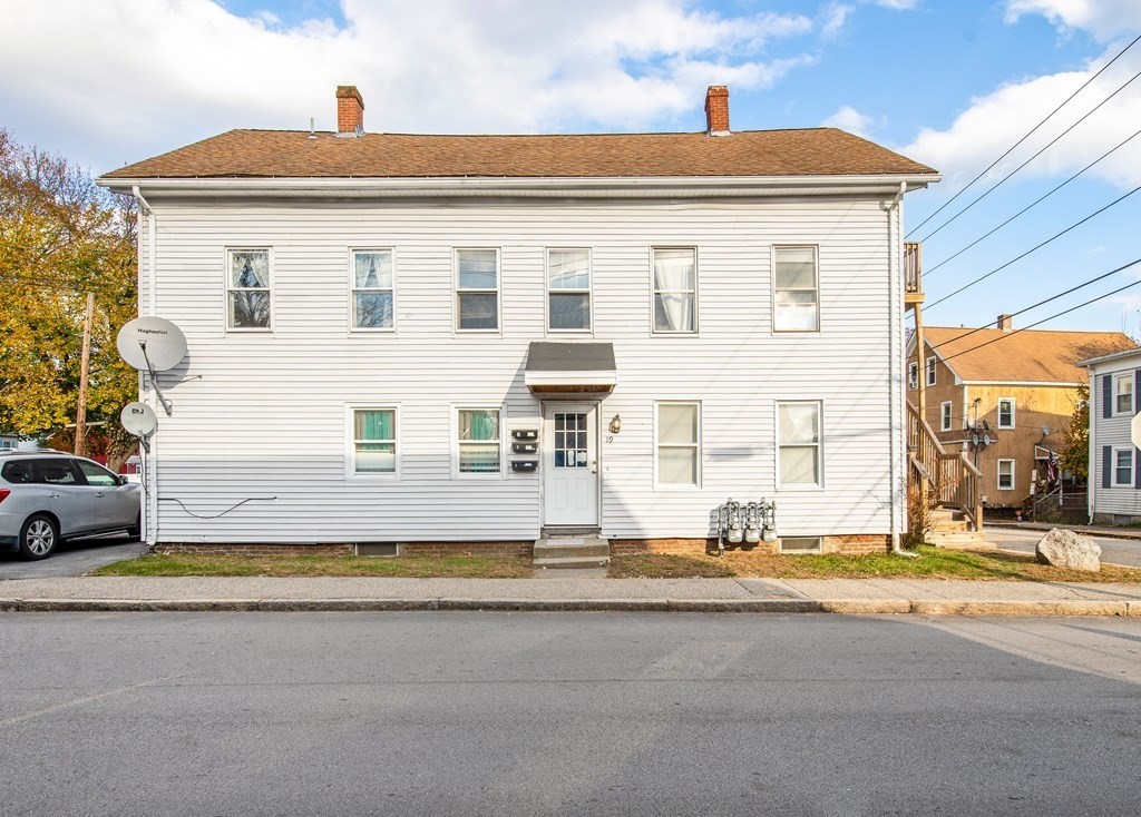 a view of building with car parked on the road