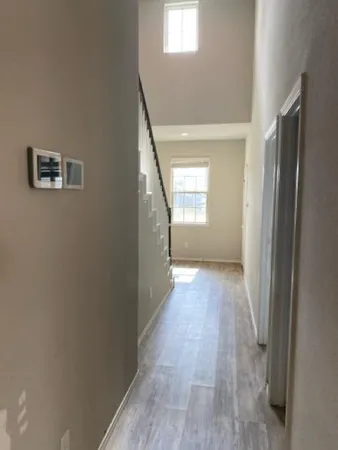 a view of a hallway with wooden floor and closet