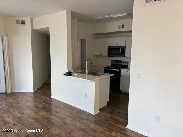 a kitchen with a refrigerator and a stove top oven