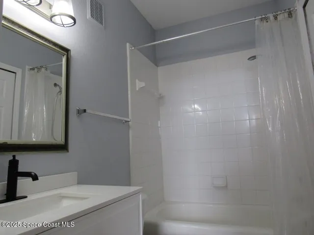 a bathroom with a shower and a sink