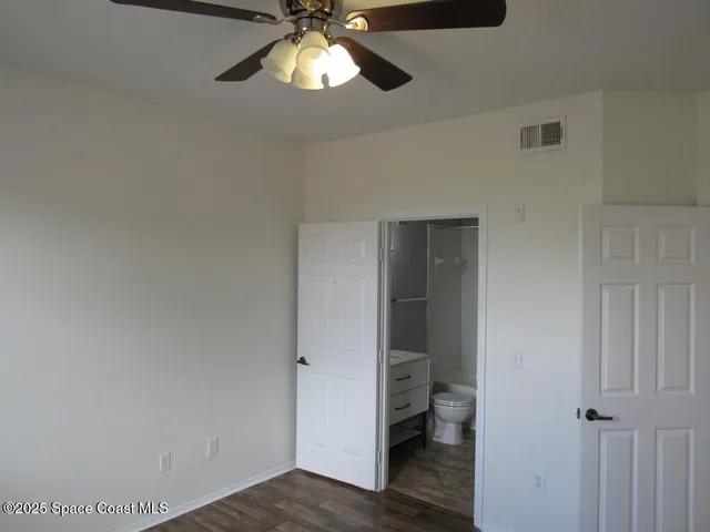 a view of a hallway with a livingroom and a chandelier fan