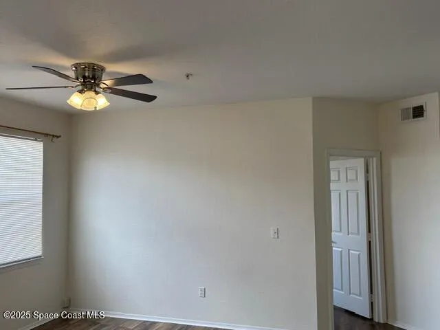 an empty room with a window and a ceiling fan