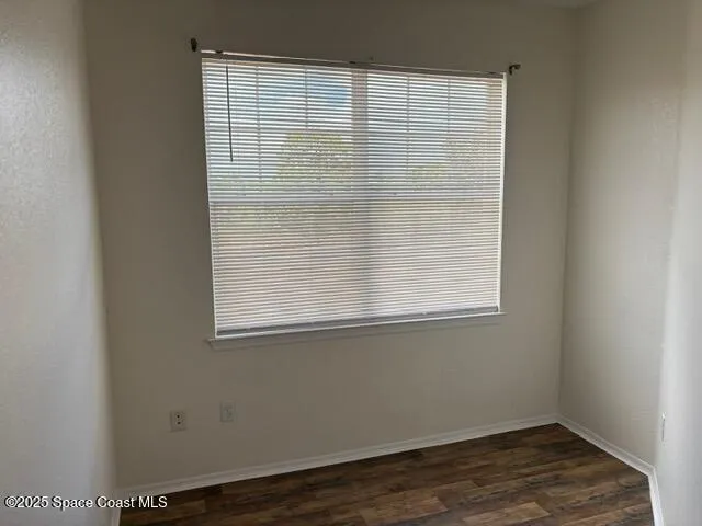 an empty room with wooden floor and a window