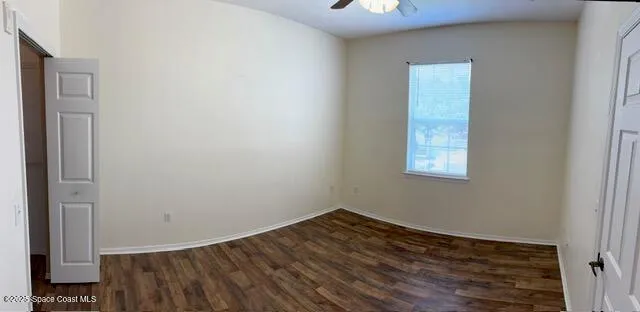 a view of a room with wooden floor and a window