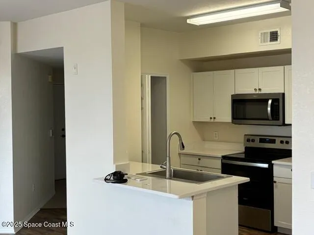 a kitchen with stainless steel appliances granite countertop a sink and a microwave