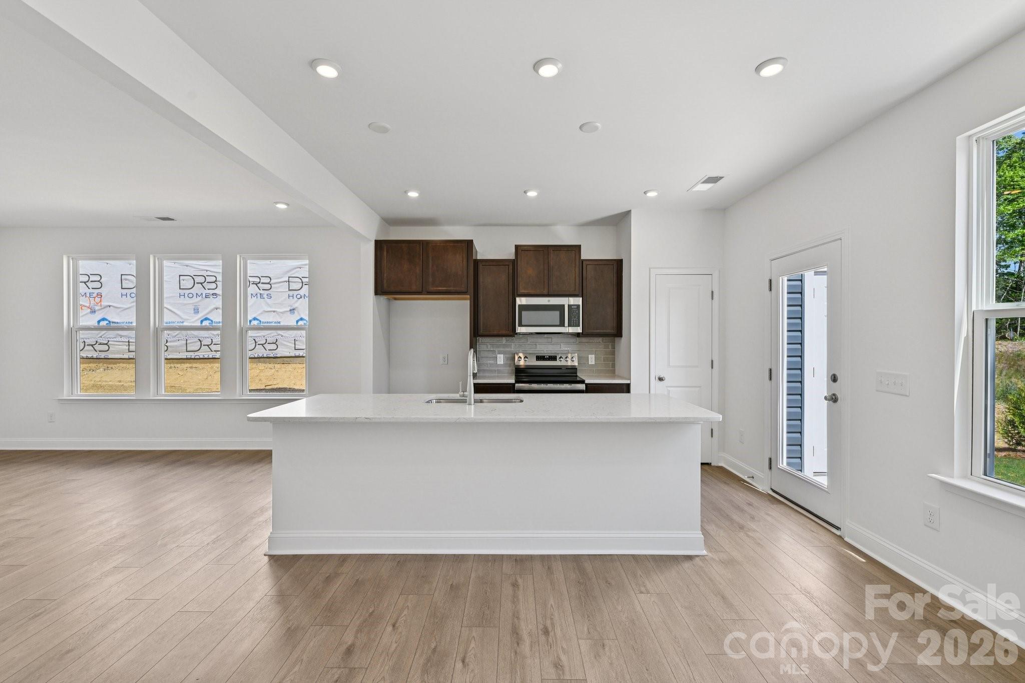 7635 Ethora Way Charlotte, NC 28216 - Photo 13 of 37 a large kitchen with stainless steel appliances a large counter top and a wooden floors