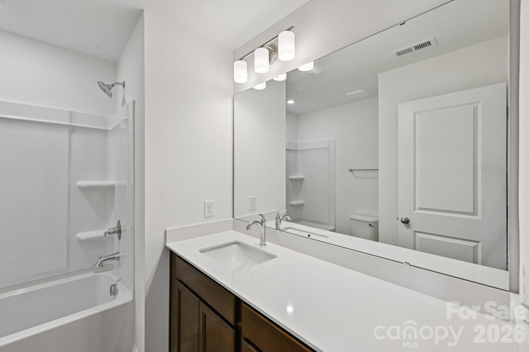 7635 Ethora Way Charlotte, NC 28216 - Photo 24 of 37 a bathroom with a granite countertop sink a toilet and shower