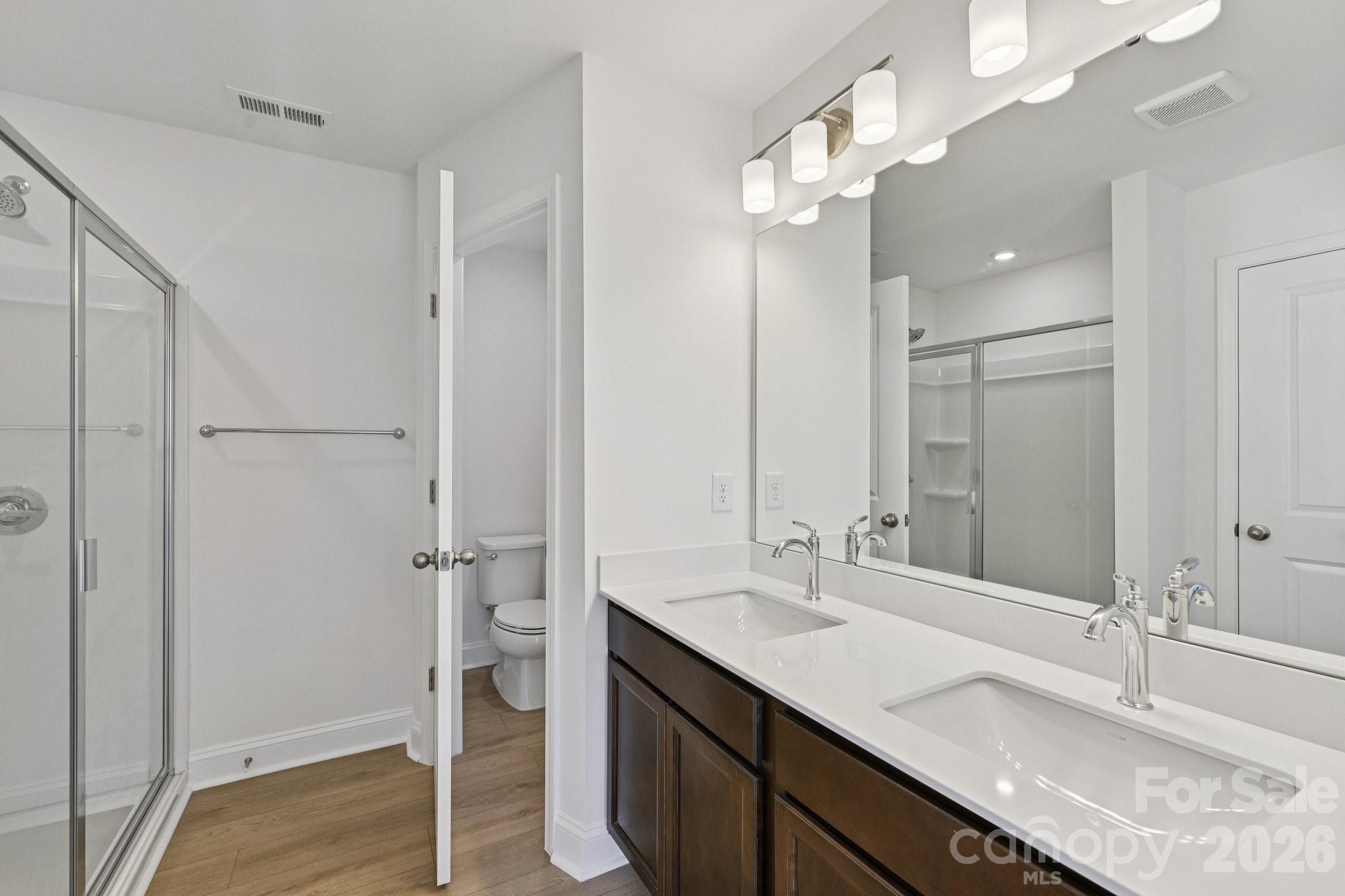 7635 Ethora Way Charlotte, NC 28216 - Photo 29 of 37 a bathroom with a granite countertop sink a toilet and shower