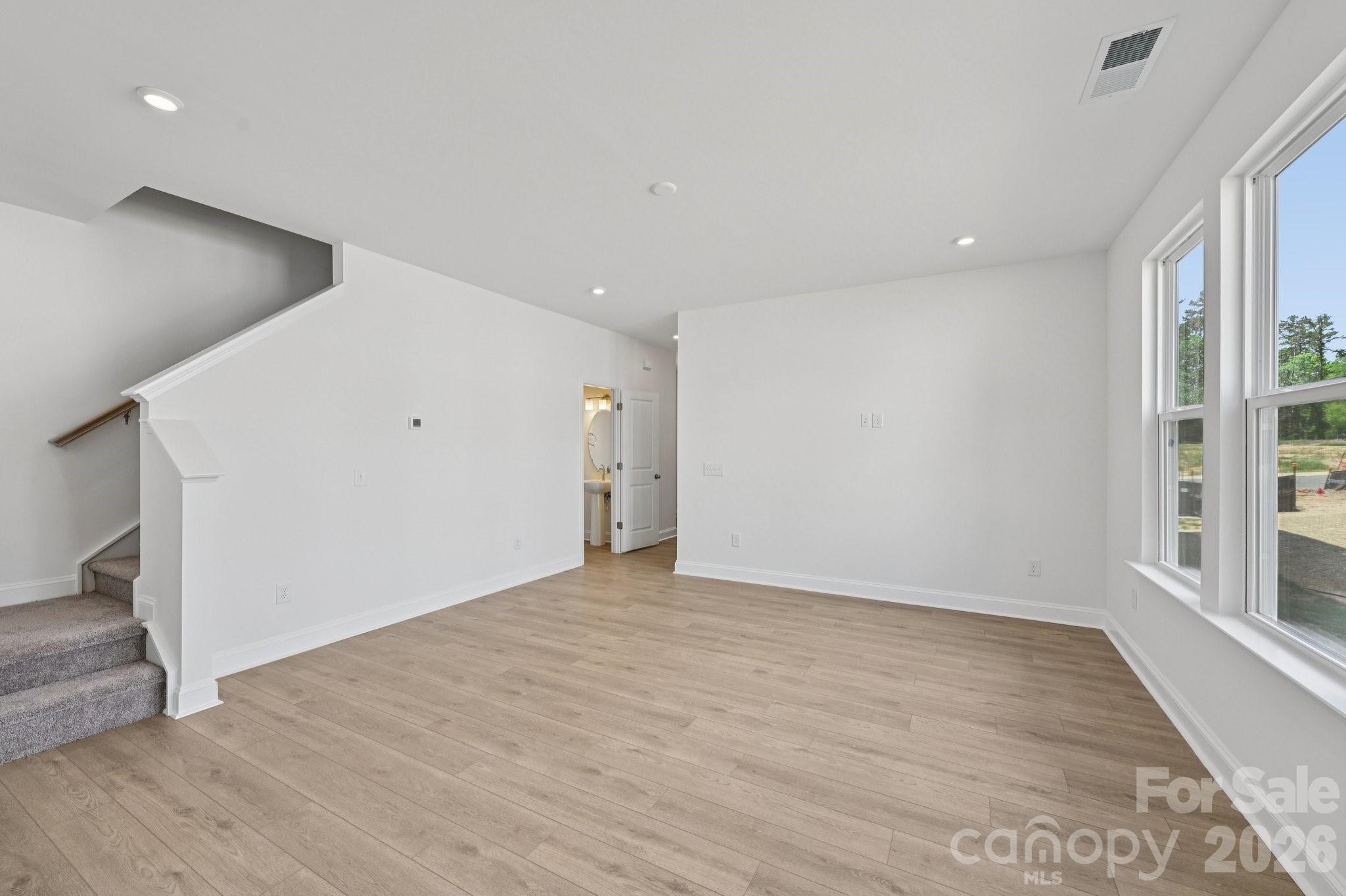 7635 Ethora Way Charlotte, NC 28216 - Photo 5 of 37 a view of an empty room with wooden floor and a window