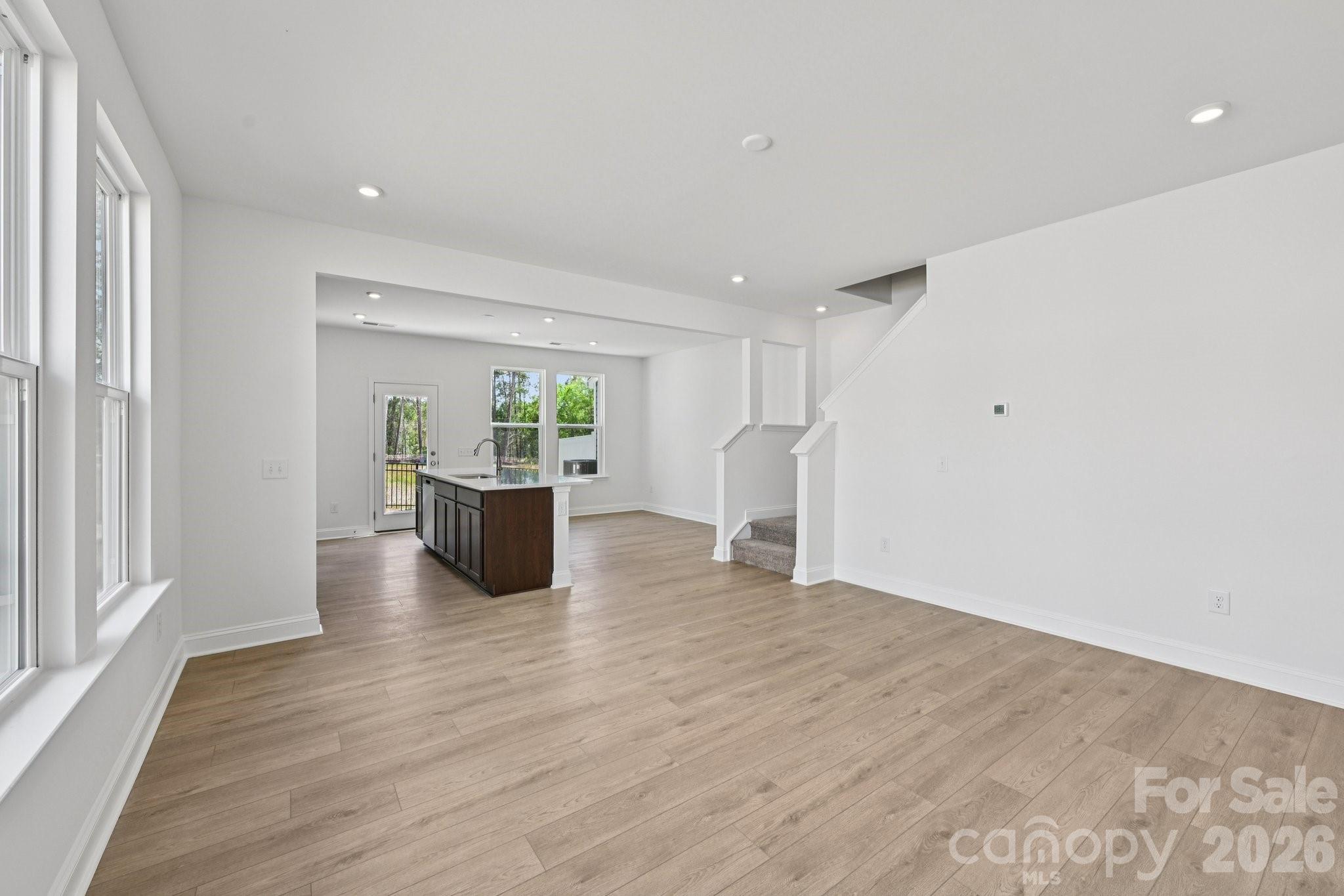 7635 Ethora Way Charlotte, NC 28216 - Photo 8 of 37 a view of a big room with wooden floor and windows