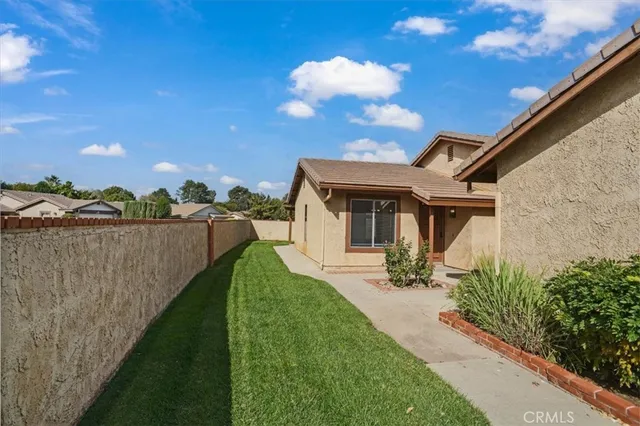 a view of a house with backyard and sitting area