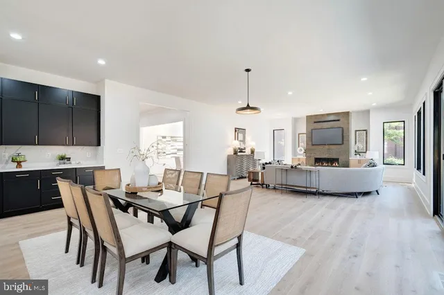 a large kitchen with granite countertop a stove a sink a dining table and chairs