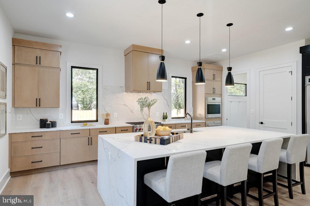 5225 Little Falls Road Arlington, VA 22207 - Photo 18 of 60 a kitchen with a dining table chairs sink and cabinets