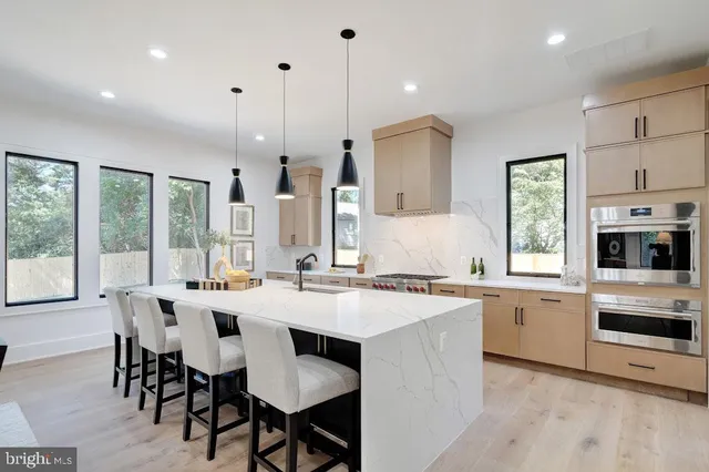 a open kitchen with stainless steel appliances kitchen island a large island in the center