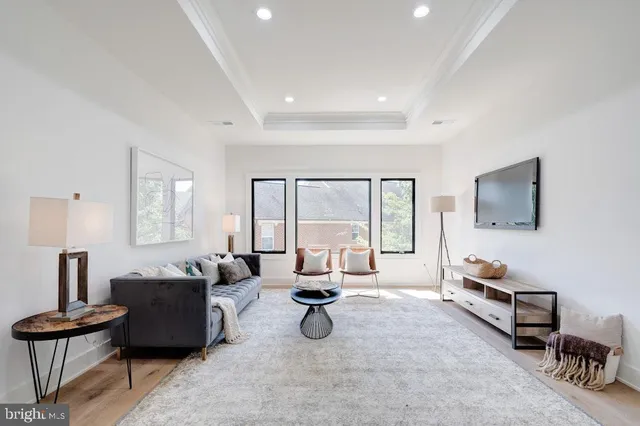 a living room with furniture floor to ceiling window and a table