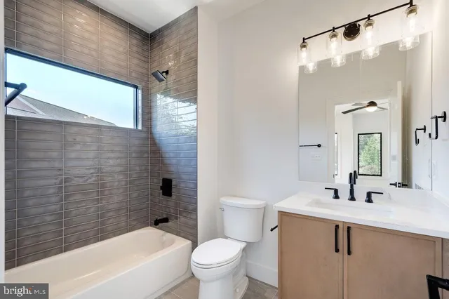 a bathroom with a granite countertop sink and a large mirror