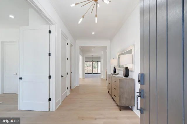 a view of a hallway with wooden floor and staircase
