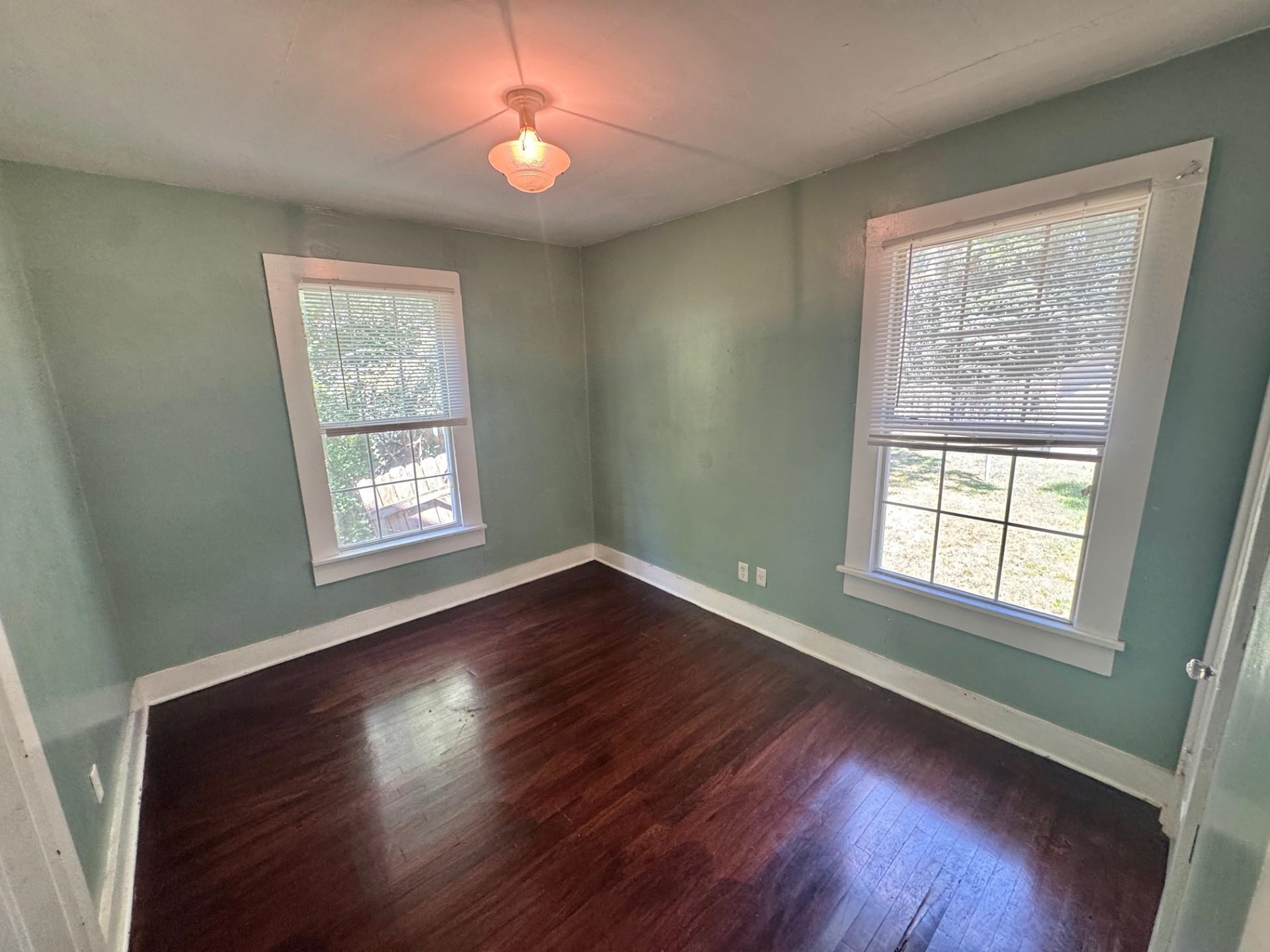 4564 Stage Road Memphis, TN 38128 - Photo 7 of 15 Unfurnished room featuring baseboards and dark wood-style floors