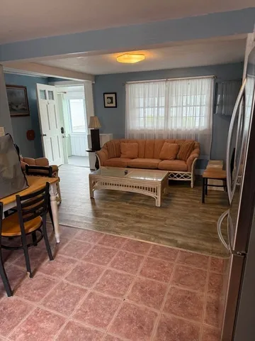 a living room with furniture a flat screen tv and a window