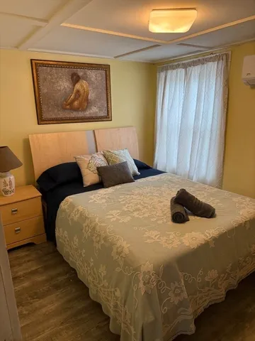 a bedroom with a bed and painting on the wall