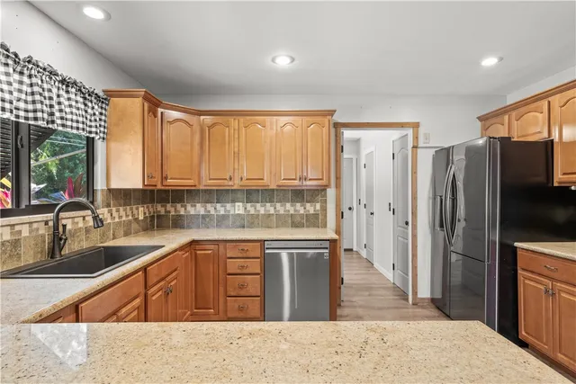 a kitchen with granite countertop a refrigerator stove top oven and sink